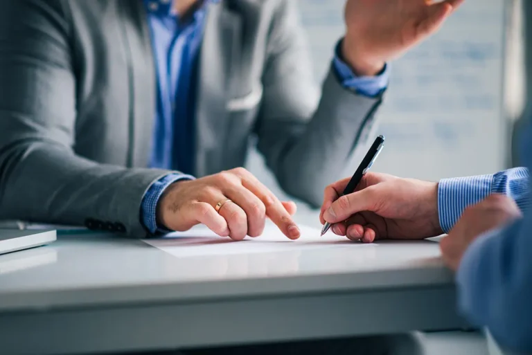 Business professionals reviewing and signing a contract with personal guarantee risks.